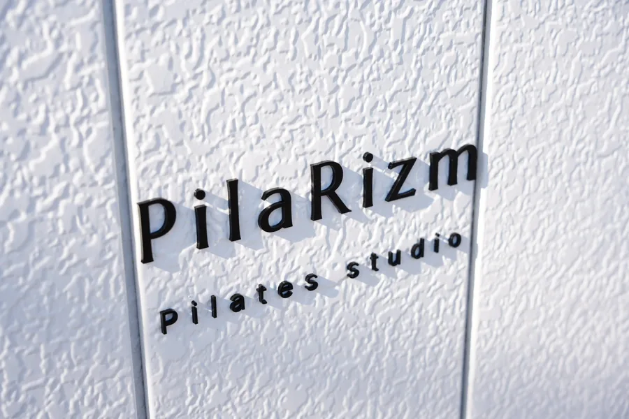 壁に掲げられた PilaRizm Pilates studio のサイン